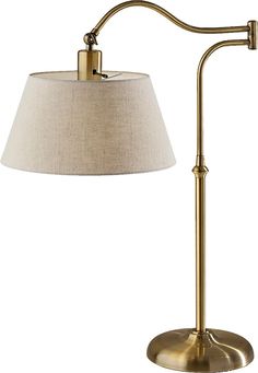 a gold lamp with a white shade on the side and a beige lampshade