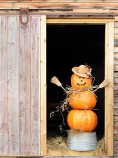 three pumpkins stacked on top of each other in an open window with hay bales