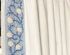 the curtains are closed and there is a blue flower design on one side of the curtain