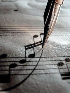 a pen is sitting on top of sheet music