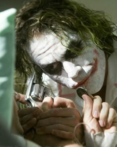 a man dressed as the joker holding a cell phone