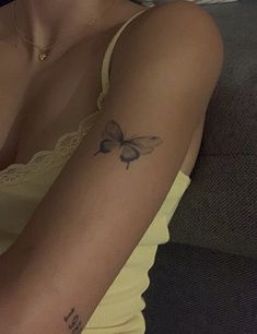 a woman with a butterfly tattoo on her arm