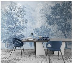 a dining room table with two chairs and a wallpapered forest behind the table