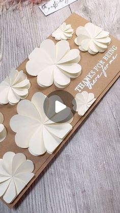 a card with white paper flowers on it