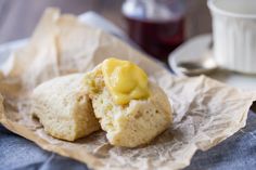 two biscuits with butter on them sitting next to a cup