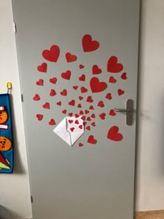 a door decorated with paper hearts and an origami heart on the front side