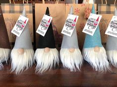 several gnome hats with tags on them sitting on a wooden table next to brown paper bags