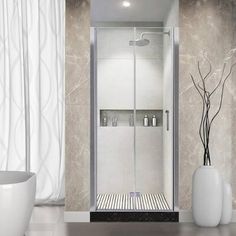 a bathroom with a glass shower door next to a bathtub and vase on the floor