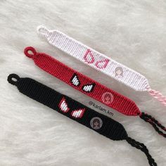 two knitted lanyards with different designs on them, one is red and the other is black