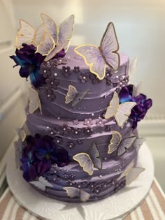 there is a purple cake with butterflies on it