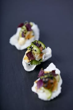 small appetizers are arranged on a black surface