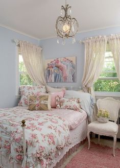 a bed room with a neatly made bed and a chandelier hanging from the ceiling