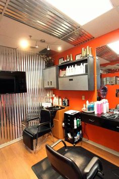 a hair salon with orange walls and black chairs