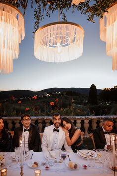 a group of people sitting at a table with plates and glasses in front of them