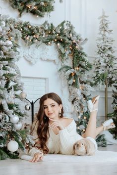 a woman laying on the floor in front of christmas trees