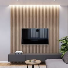 a living room with a couch, coffee table and television mounted on the wall above it