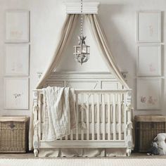 a white crib with a chandelier hanging from it's ceiling in a nursery