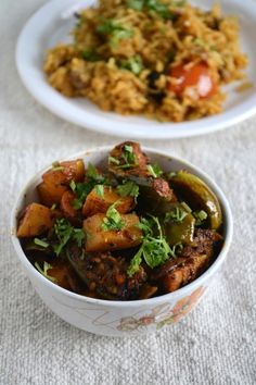 two white bowls filled with food on top of a table