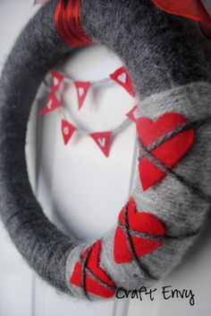 a gray wreath with red hearts on it