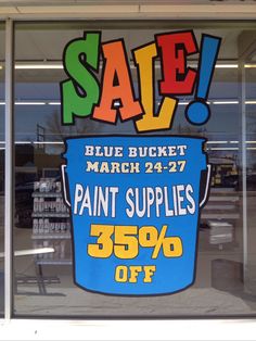 a sign advertising paint supplies for sale in a store window