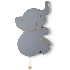 an elephant shaped hook is hanging on the wall and it's painted gray with gold accents