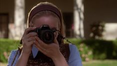 a woman holding a camera up to her face