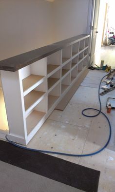 an unfinished room with shelves and tools on the floor