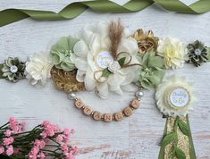 some flowers are sitting on a table with green ribbons and name tags around the edges