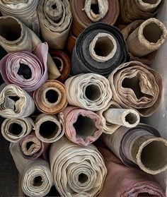 many rolls of cloth are stacked in a box