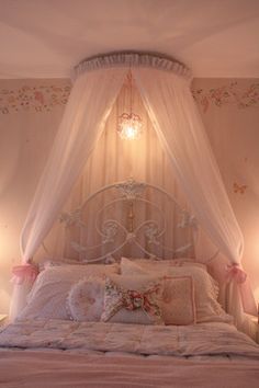 a bed with a canopy over it and pillows on top of the bedspread