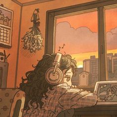 a person sitting at a desk with headphones on and looking out the window while listening to music