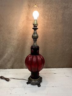 a lamp that is sitting on top of a white table next to a light bulb