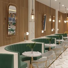 the interior of a restaurant with green velvet booths and gold trimmings on the walls