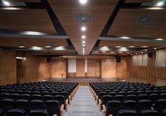 an empty auditorium with rows of seats and projector screen