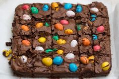 a square cake with chocolate frosting and candy eggs on it