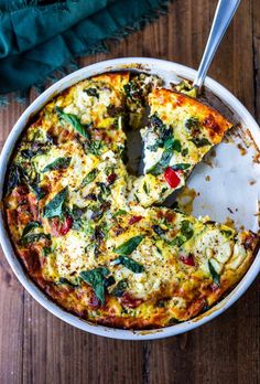 a close up of a pizza in a pan on a wooden table with a slice missing