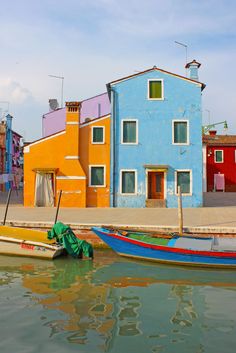 two boats are docked in front of colorful houses