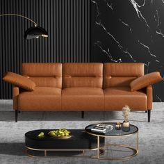 a modern living room with black walls and marbled flooring, an orange leather sofa and coffee table