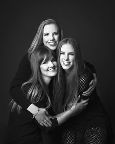 three young women hugging each other and smiling for the camera, black and white photo