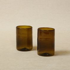 two brown glass vases sitting next to each other