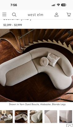 a white couch sitting on top of a wooden floor next to a spiral stair case