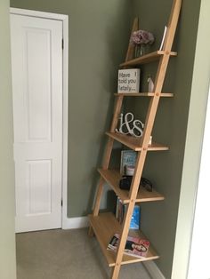 a wooden book shelf with books on it in a room next to a doorway and door