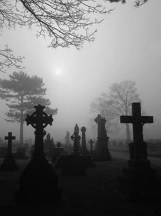 a graveyard with crosses in the fog