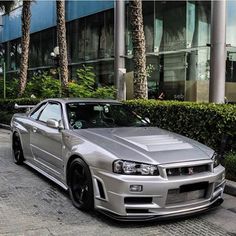 a silver sports car parked in front of a building