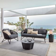 a living room filled with furniture next to a swimming pool