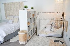 a bedroom with two beds, a book shelf and a white rug on the floor