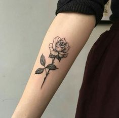 a woman's arm with a rose tattoo on the left side of her arm