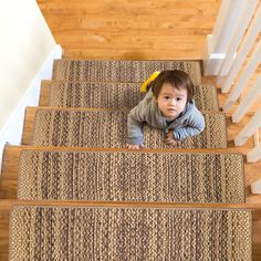 a toddler is crawling down the stairs with his hands in his pockets and looking at the camera