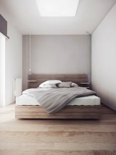 a bed sitting on top of a wooden floor next to a white wall and window