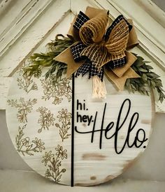 a sign that says hi hey hello hanging from the side of a building with a bow on it